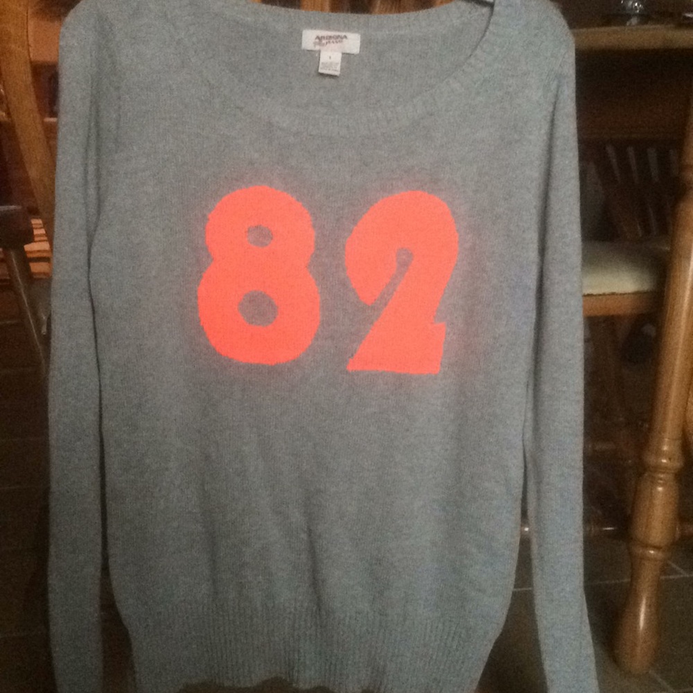 gray sweater with “82” in bright orangey pink